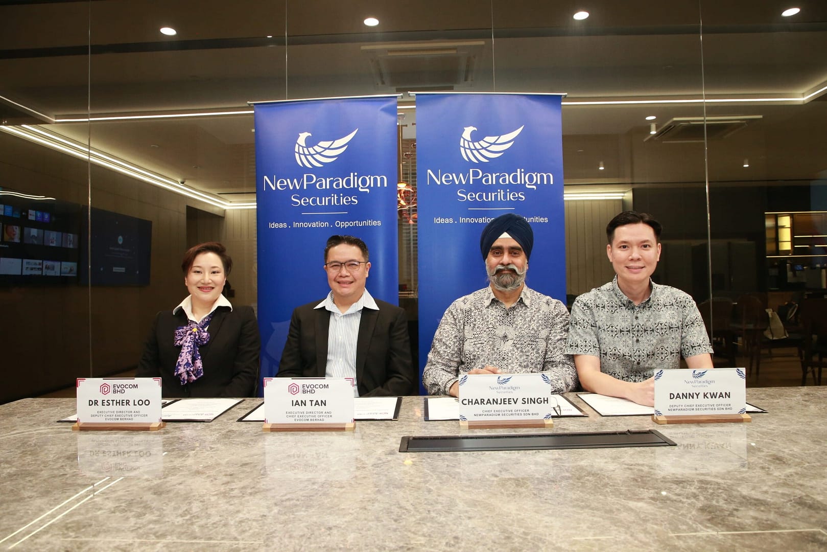 Evocom and NewParadigm Securities executives sign underwriting agreement for Evocom ACE Market Listing
